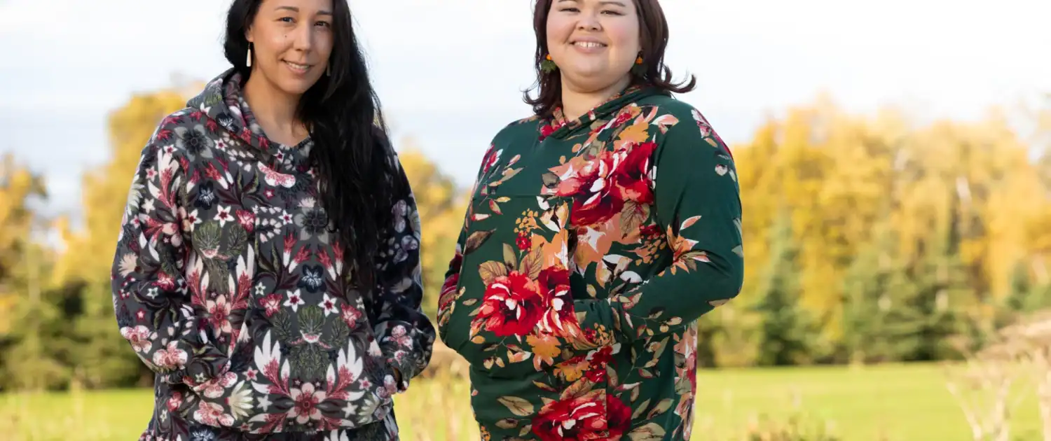 Two women in kuspuks outside in the fall