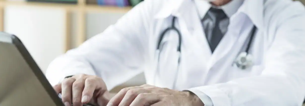 Doctor typing on a laptop