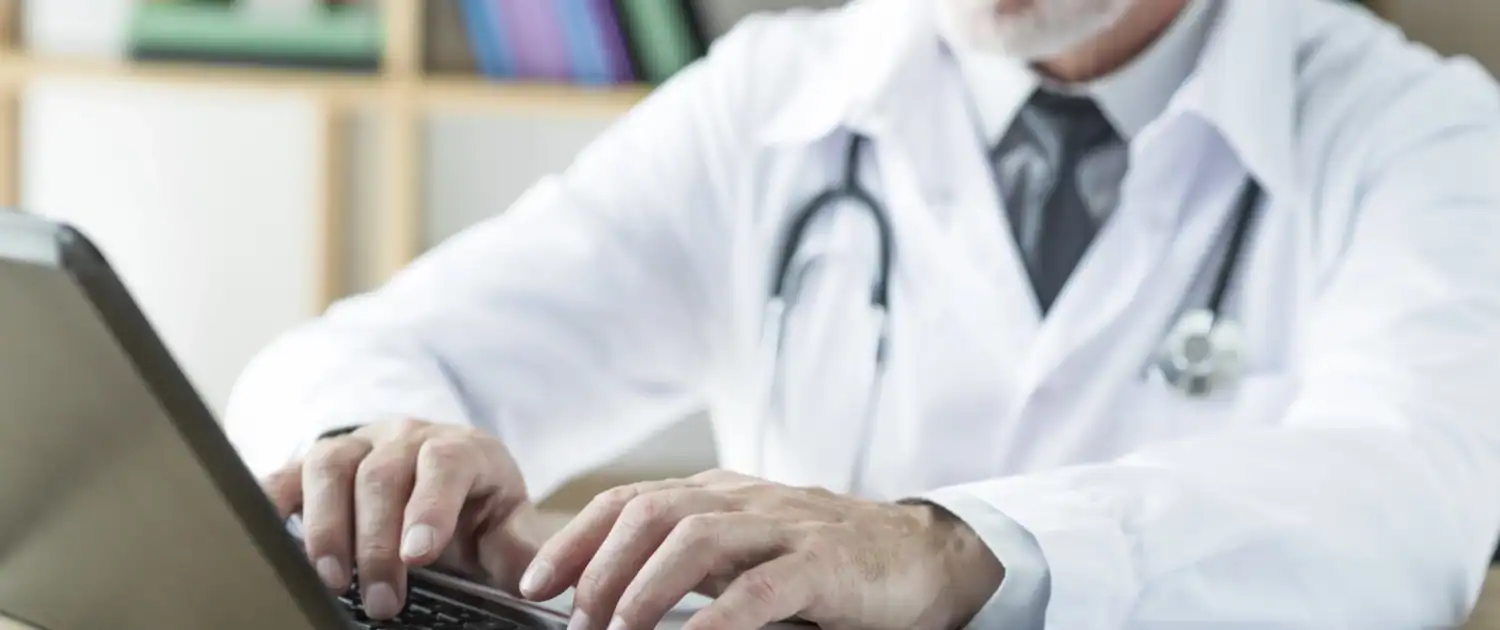 Doctor typing on a laptop