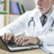 Doctor typing on a laptop