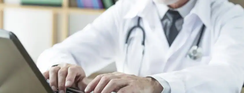 Doctor typing on a laptop